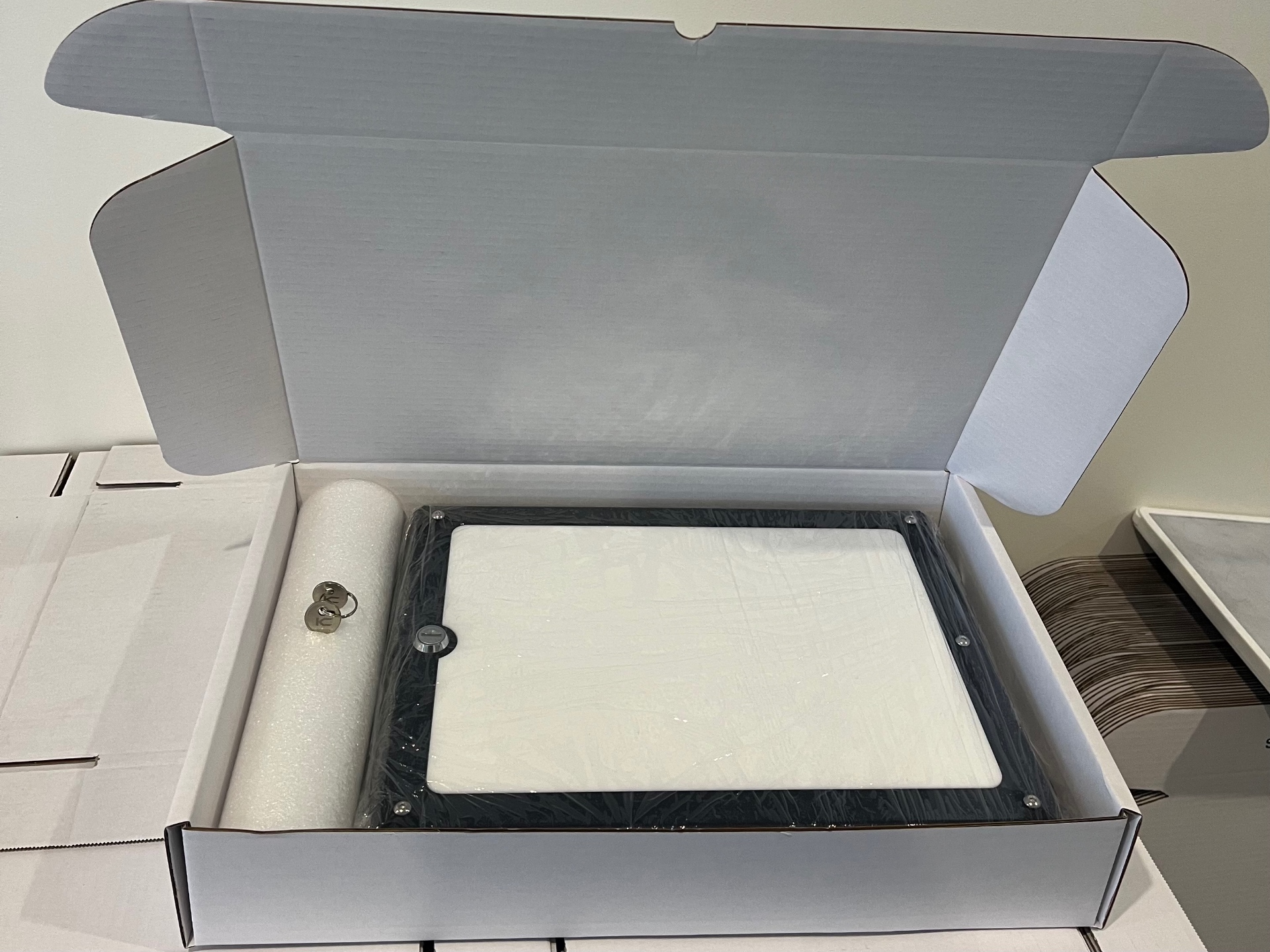 a finished mount boxed for dispatch with the keys taped inside the lid, on a stack of Kettle Customs shipping boxes