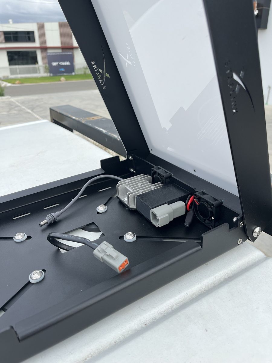 Inside the open Power Hub: the harness's sealed plug coming up through the floor next to the converter and fans