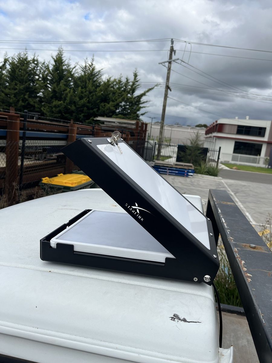 The Power Hub lid swinging shut over the Starlink Mini, with the key in the lock